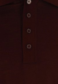 Polo shirt bordeaux con colletto strutturato, dotato di cinque bottoni scuri lungo la pattina e una fine trama a costine.
