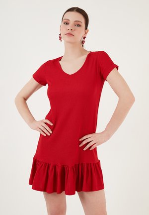 Red short-sleeved dress with a V-neck, featuring a flared ruffled hem and a textured fabric. No visible patterns or hardware details.