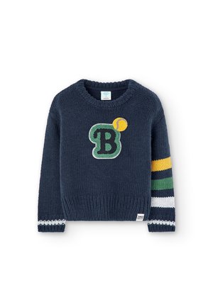 Granatowy dzianinowy sweter z zieloną literą B i żółtą piłką tenisową z przodu oraz żółtymi, zielonymi, białymi i granatowymi paskami na prawym rękawie.