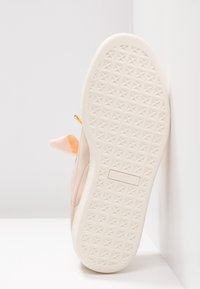 Chaussure en daim rose avec une semelle en caoutchouc blanche texturée présentant un motif d'étoiles, conçue avec une fermeture éclair accent doré et une doublure intérieure douce orange.