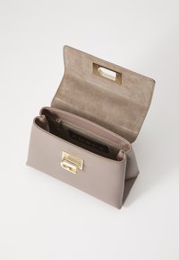 Sac à main en cuir beige avec une finition texturée, quincaillerie dorée et une poche intérieure zippée. Le rabat ouvert révèle une doublure en daim.