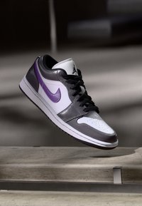 Nike Air Jordan sportbačiai su balta, pilka ir violetine odine viršutine dalimi; perforuota pirštų dalis, juodi raišteliai ir violetinis "swoosh" logotipas.