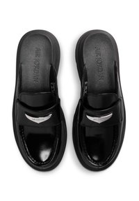 Deslizador de charol negro con una tira ancha, con un acento plateado y la marca "AIR JORDAN" en la planta. Textura suave.