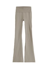 Pantalon évasé en maille côtelée beige avec une large taille haute et un petit logo métallique sur le côté droit.