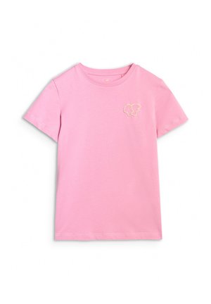 Młoda dziewczyna o długich brązowych włosach, nosząca różowy T-shirt, lawendową bluzę na zamek, pasujące spodnie oraz czarno-białe trampki, stoi pewnie.