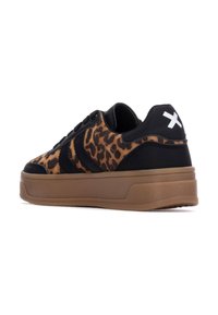 Zapatillas de leopardo con detalles en cuero negro, forma redondeada y una suela gruesa de goma. Presenta un logo blanco en el talón.