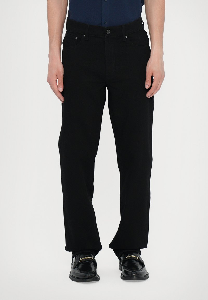 Black denim jeans with a straight cut, five-pocket design, and silver hardware details. Fabric has a smooth, slightly textured finish.