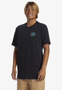 Camiseta negra de manga corta hecha de algodón, con un logo de ola colorido en el área del pecho izquierdo, cuello redondo y corte relajado.