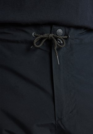 Shorts noirs avec une taille élastique à cordon de serrage, présentant une texture lisse et une fermeture à bouton. Le cordon de serrage est dans un design tressé contrastant.