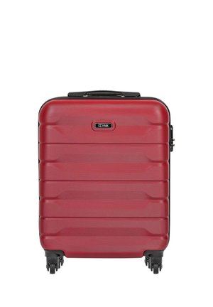 Czerwona walizka z twardą skorupą z poziomymi żebrowaniami, czarną rączką na górze, czterema czarnymi obrotowymi kółkami oraz plakietką z logo „OCHNIK” na środku z przodu.