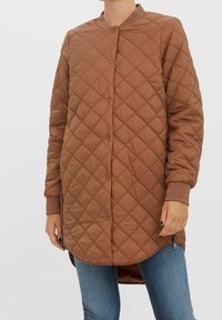 Veste longue matelassée marron avec un col rond, une fermeture à boutons et des poignets côtelés. Dispose de fermetures à glissière latérales et d'un ourlet légèrement plus long à l'arrière.