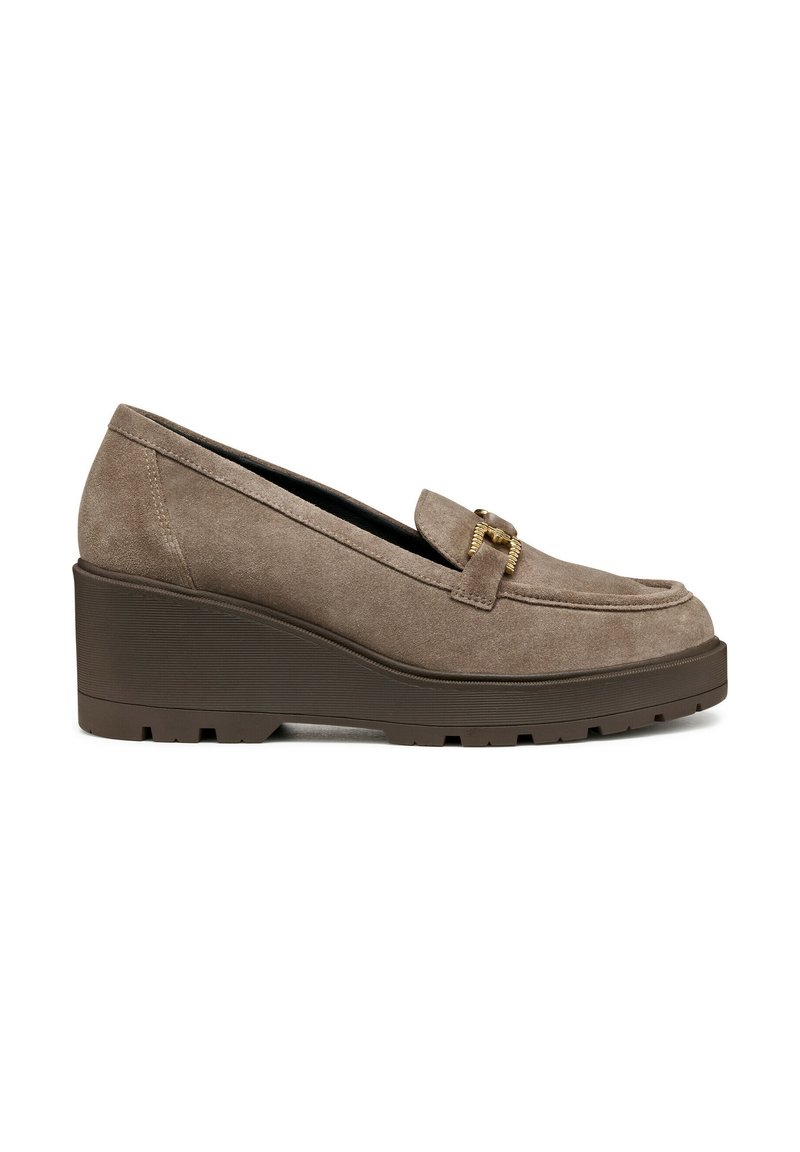 Mocasines de cuña de ante marrón con punta redondeada y un aro decorativo de metal dorado. Suela de goma texturizada para mayor agarre.