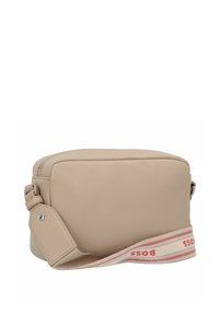 Borsa a tracolla in pelle beige con forma rettangolare, chiusura con zip e una tracolla in tessuto con logo rosso e dettagli.