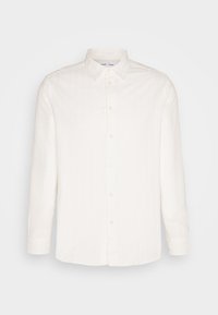 Chemise blanche à manches longues avec un col à boutons, en tissu texturé avec des rayures verticales subtiles, cinq boutons sur le devant.