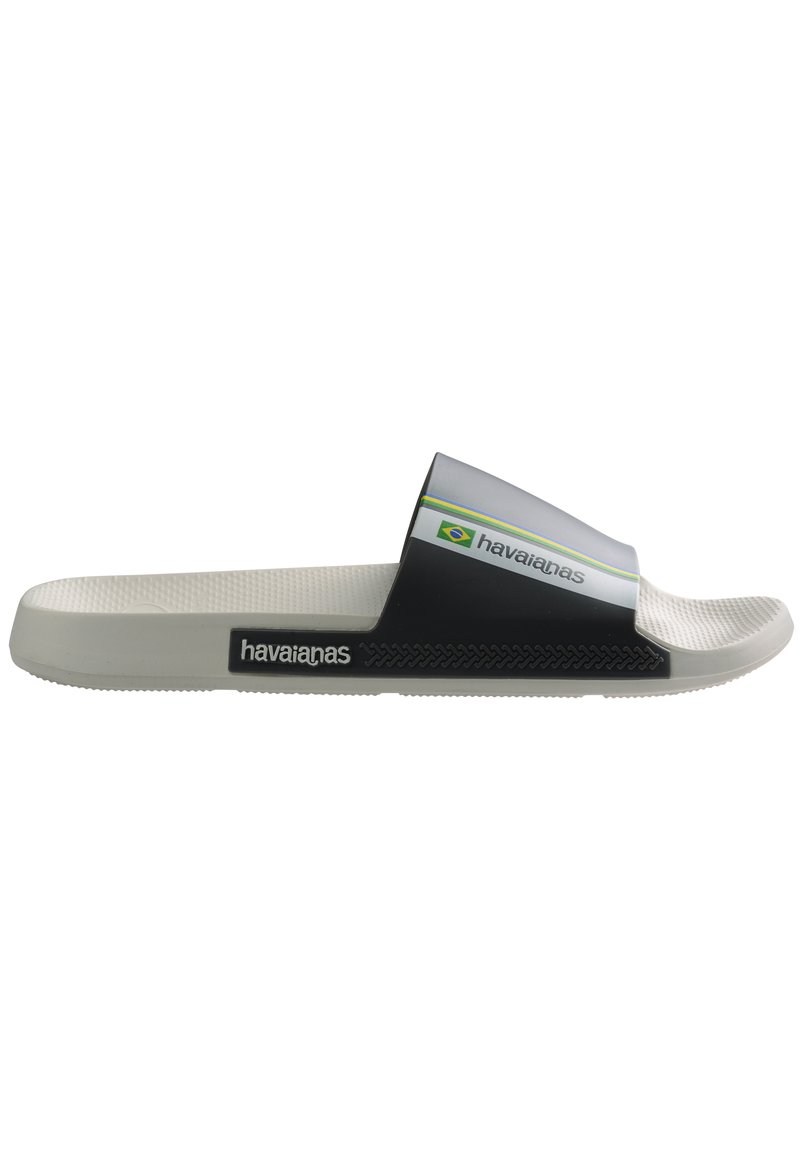 Sandalie in gomma in bianco e nero con suola testurizzata, logo sulla fascia e accento multicolore. Caratterizzate da un design minimalista.