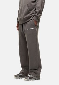 Grijze joggingbroek met een ontspannen pasvorm, voorzien van een trekkoord in de taille en de tekst "GOODFORNOTHING" in het wit op de linkerheup.