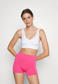 Bralette branco de decote redondo com alças largas, combinado com calções de cintura alta em rosa brilhante, ambos feitos de tecido liso e elástico.