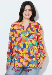 Värikäs pitkähiha blouse, jossa on erilaisia jäätelökuvastoja pinkissä, keltaisessa, sinisessä ja vihreässä punaisella taustalla.