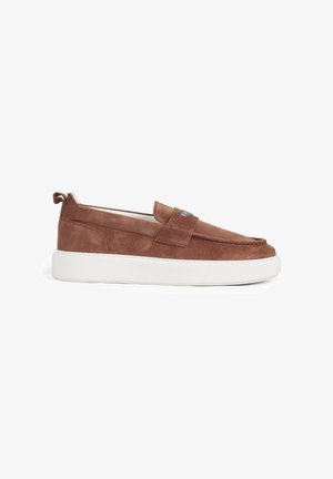 Mocassino slip-on in suede marrone con suola in gomma bianca e dettaglio di una fascia cucita sulla parte superiore, mostrato di profilo su sfondo bianco.