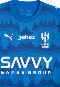 Blå polyester sportsjersey med et geometrisk mønster, rund krave og hvid branding for "SAVVY GAMES GROUP" og "jahez."