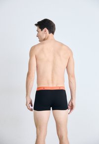 Sorte boxer shorts med en tætsiddende design, elastisk linning med et orange logo, glat tekstur og en midt-lår længde.