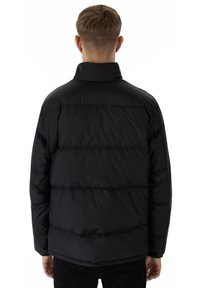 Giacca a vento nera con colletto alto, caratterizzata da un motivo trapuntato e polsini elastici. La vista posteriore mostra dettagli di cuciture orizzontali.