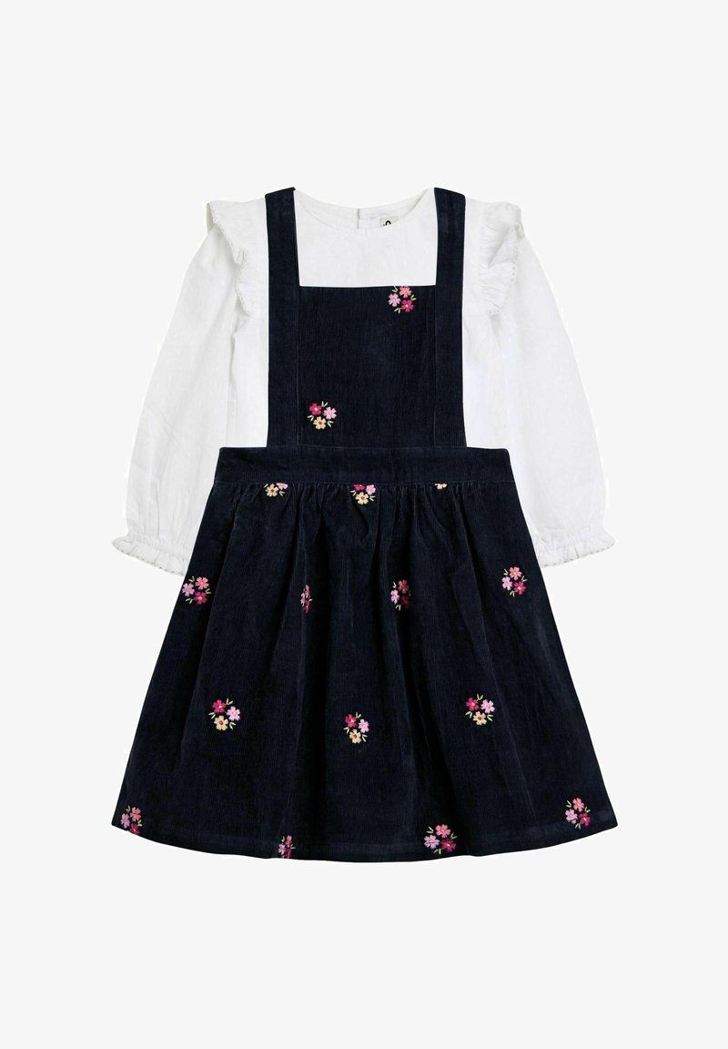 Marineblaues Cordkleid mit gestickten Blumen, ausgestattet mit einem weißen Langarmoberteil mit Rüschen an den Manschetten und einem taillierten Oberteil mit Schulterträgern.