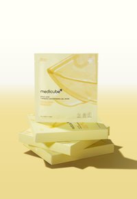 Emballage de masque gel jaune vif avec un design géométrique, le nom de la marque "medicube" et les détails du produit. Boîtes empilées en dessous.