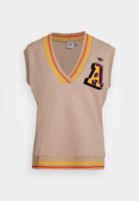 Beige ärmlös tröja med V-ringning, orange och gul randig krage och fåll, med ett broderat bokstaven "A" i vinrött och gult.