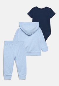 Kisgyermek ruhaszett, amely egy sötétkék rövid ujjú bodyból, világoskék kapucnis pulóverből és hozzáillő melegítőnadrágból áll. Pamut anyag, puha tapintású, elasztikus derékrész.
