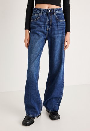 Jeans de mezclilla azul de pierna ancha con una cintura alta, que cuentan con bolsillos frontales, costuras de contraste y un cierre clásico de botón.