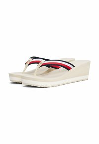 Infradito a forma di scalino con suola in gomma beige, righe nere e bianche e dettagli dorati sulle cinghie. Plantare testurizzato per aderenza e comfort.