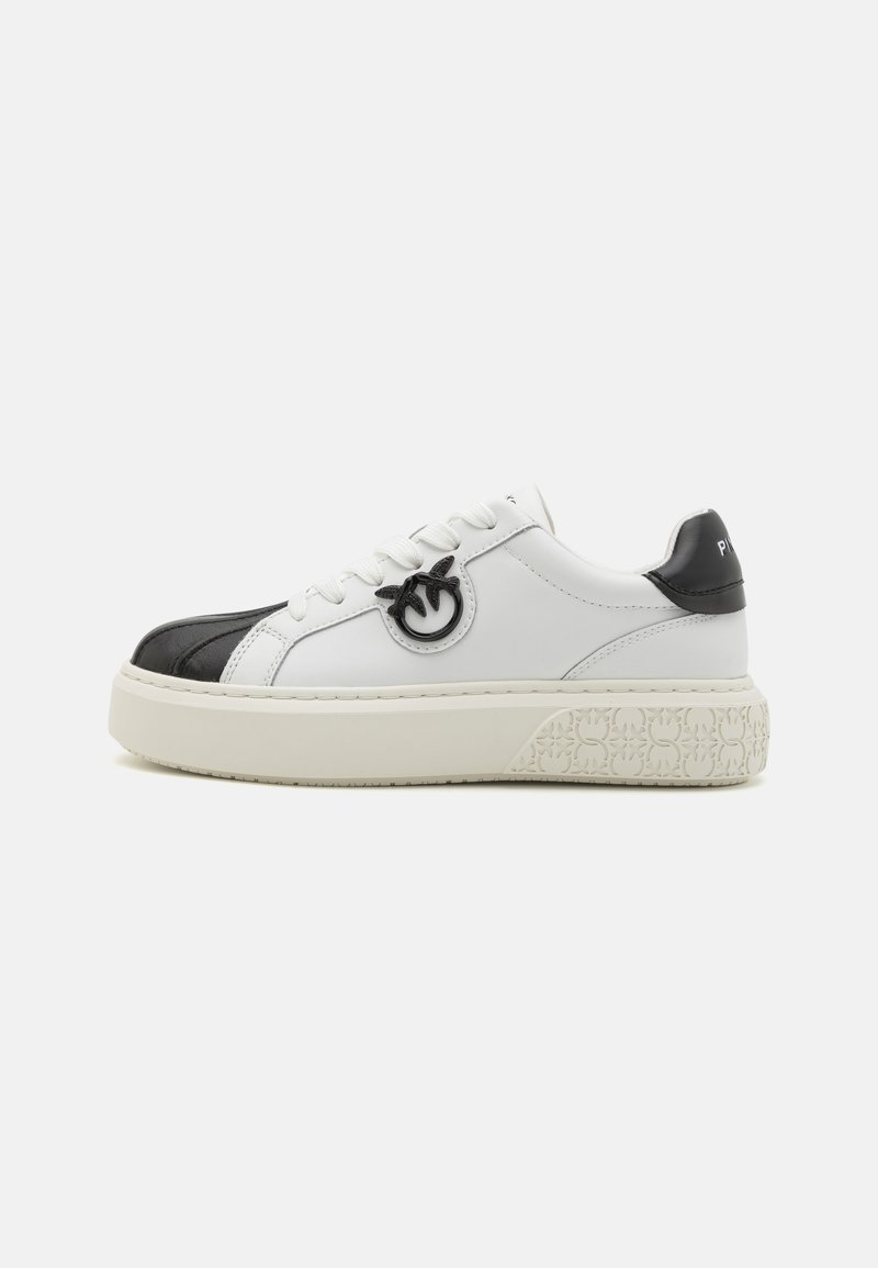Black and white leather sneakers with a textured platform sole, prominent logo detail on the side, and contrasting black toe design.