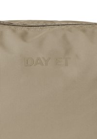 Pouch beige con texture e chiusura a zip. Presenta il logo in rilievo "DAY ET" sul davanti, realizzato in materiale sintetico resistente.