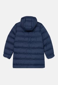 Casaco puffer azul-marinho com capuz, apresentando um design acolchoado, punhos elásticos e uma bainha traseira ligeiramente mais longa para maior cobertura.