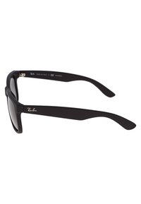 Ochelari de soare din plastic negru, cu lentile întunecate, un design rectangular al ramei și un logo metallic gravat pe lateral. Temelurile sunt ușor curbate.