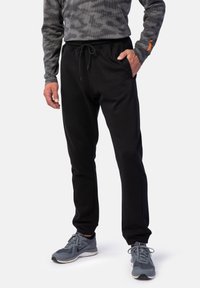 Schwarze Sweatpants aus weichem Stoff, mit einem elastischen Bund und Kordelzug sowie schmal zulaufenden Beinen für eine enge Passform.