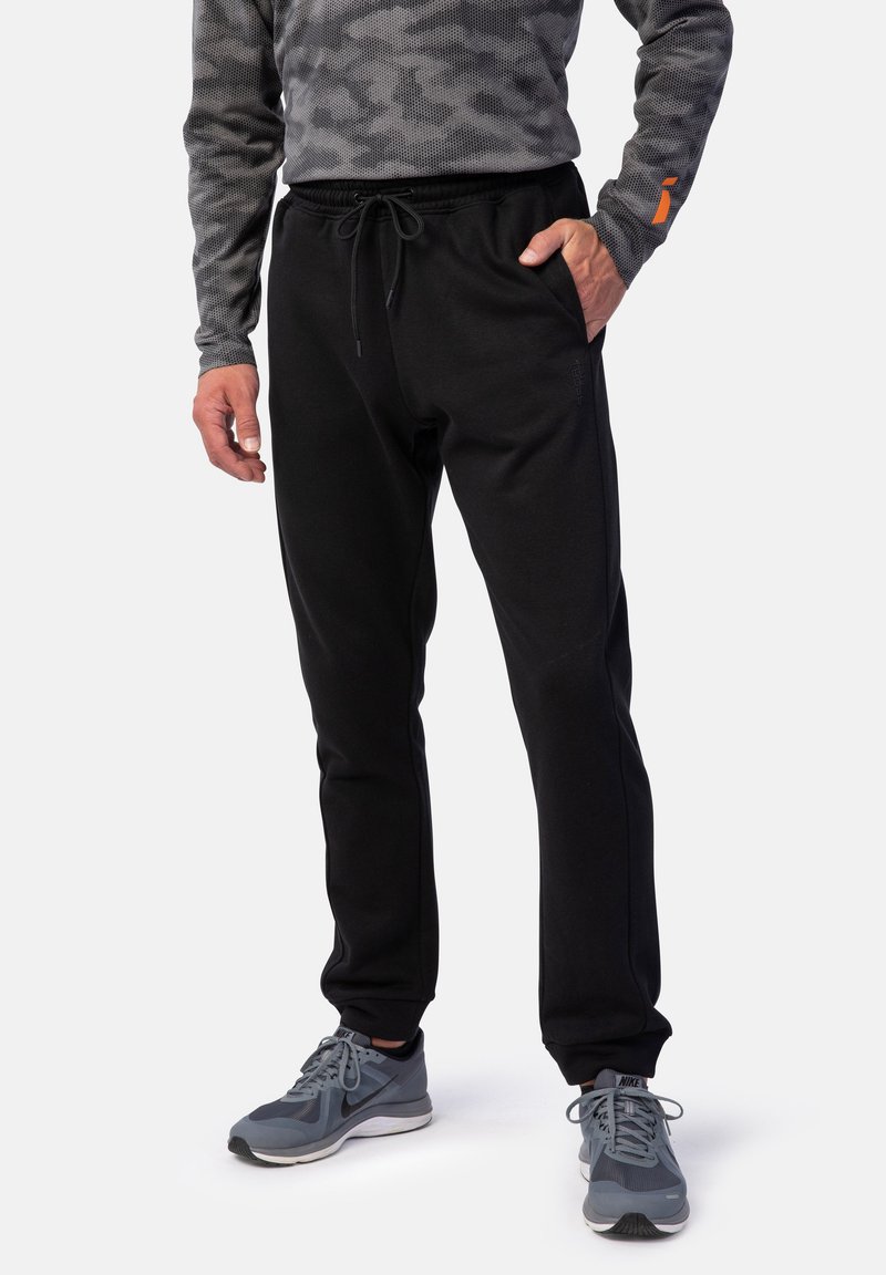 Schwarze Sweatpants aus weichem Stoff, mit einem elastischen Bund und Kordelzug sowie schmal zulaufenden Beinen für eine enge Passform.