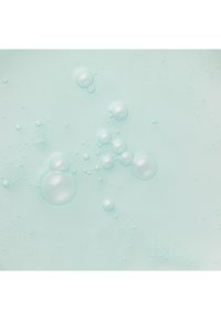 Klarer Flüssigkeit mit einem sanften Minzton, die verschiedene Blasengrößen und schaumige Texturen vor einem glatten Hintergrund zeigt.