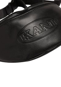 Bolso de cintura negro de cuero con cierre de cremallera, que presenta un logotipo en relieve y una textura suave. Correa ajustable para un uso seguro.
