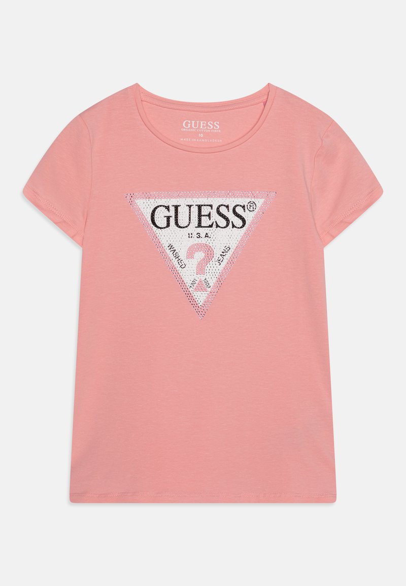 T-shirt en coton rose clair avec un logo triangulaire noir et blanc orné de rhinestones, manches courtes et col rond.