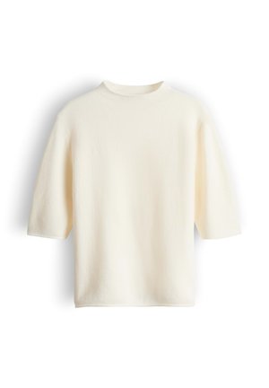 Kurzes, cremefarbenes Oberteil aus weichem, strukturiertem Stoff. Verfügt über einen hohen Kragen und eine lockere, kastige Silhouette.