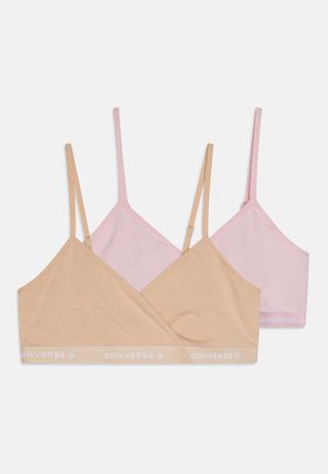 To bralette i beige og lys rosa, laget av myk stoff, med tynne stropper og et trykt "Converse"-logo på båndet.