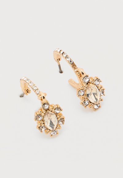 Σκουλαρίκια σε χρυσό τόνο με διαφανείς κρύσταλλους μαρκίζ και στρογγυλούς τοποθετημένους σε λουλουδένιο σύμπλεγμα, με καμπυλωτούς καρφίτσες όπου είναι ενσωματωμένοι κρύσταλλοι.