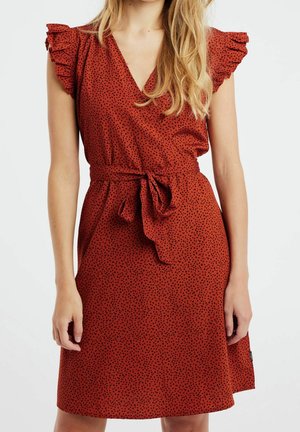 Robe rouge avec un décolleté en V, des manches à volants et un motif à pois noirs. Attachée à la taille, fabriquée en tissu léger au toucher doux.