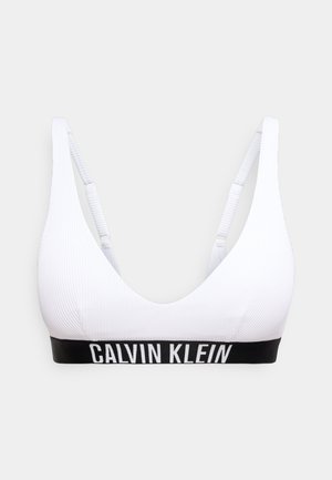 Bralette blanc côtelé avec bretelles réglables et bande élastique noire ornée du texte blanc "Calvin Klein".