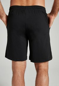 Schwarze Baumwollshorts mit einem elastischen Bund und Seitentaschen. Schlichtes Design mit geradem Schnitt und ohne sichtbare Muster.