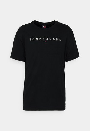 Zwart T-shirt met korte mouwen en ronde hals, voorzien van de tekst "TOMMY JEANS" en een klein Tommy Hilfiger-logo in rood, wit en blauw, gecentreerd op de borst.