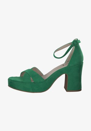 Green suede platform sandals with a wide cross strap design, a rounded toe, and a chunky heel, featuring an adjustable ankle strap.