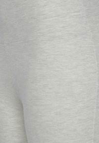 Helle graue Leggings aus weichem, dehnbarem Stoff mit glatter Textur. Verfügt über Flachnähte und ein minimalistisches Design.